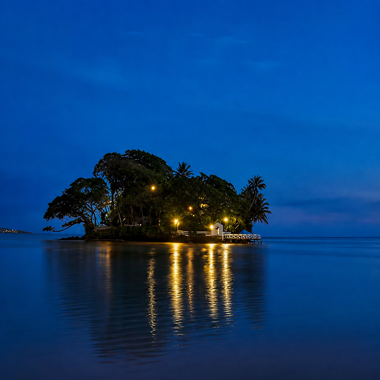 Taprobane Island illuminated at dusk in Weligama Bay