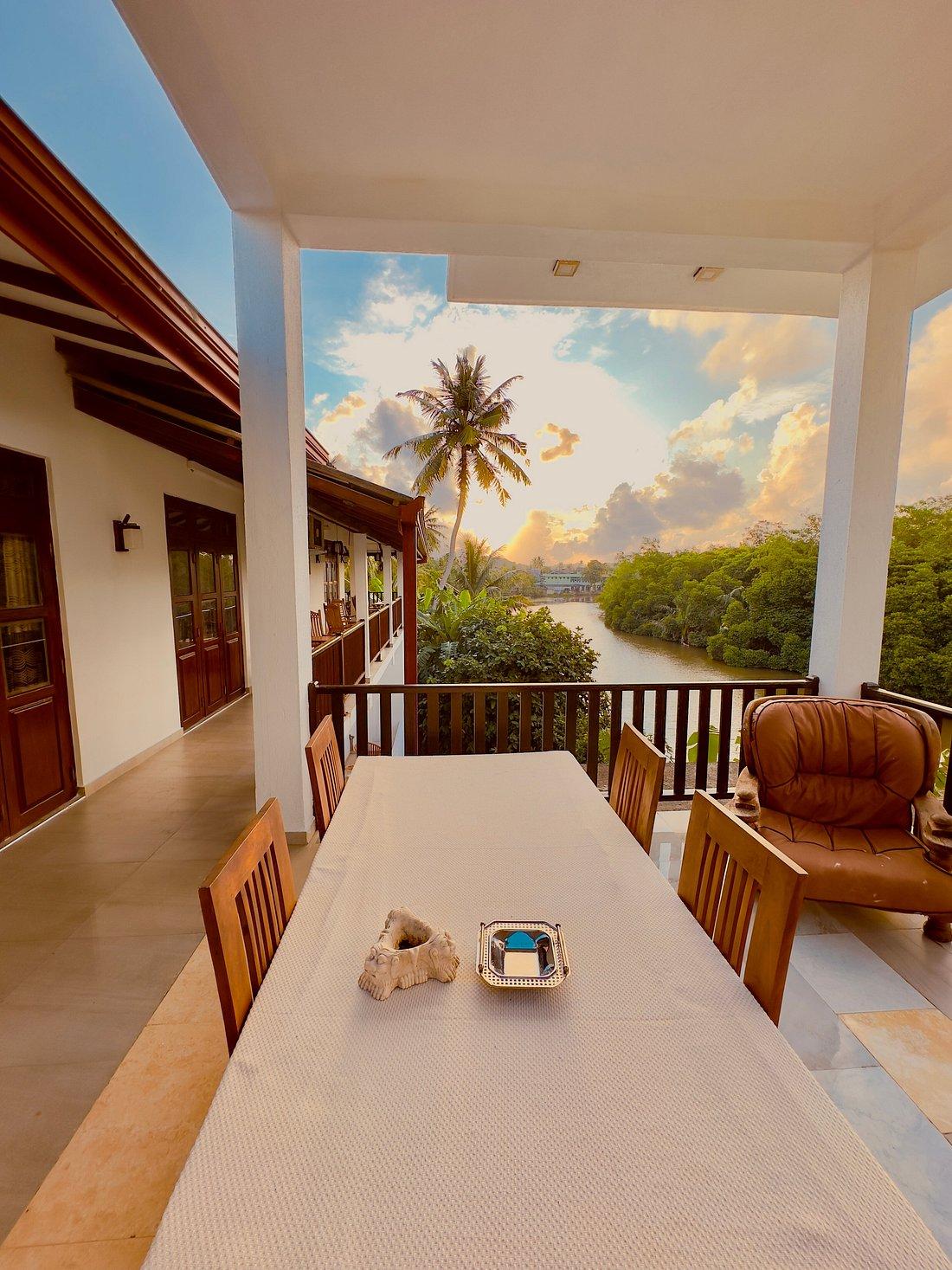 Dining table on a balcony facing the river at sunset