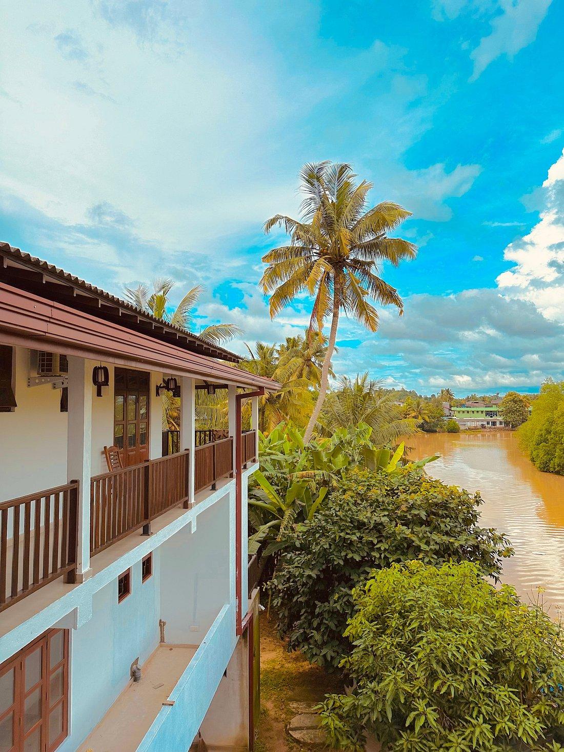 Riverwood Villa exterior beside palms and river light