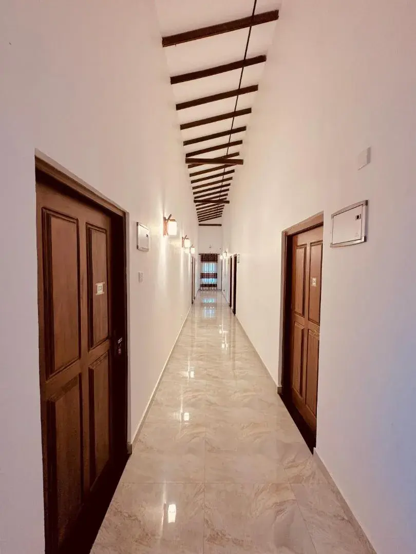 Long white corridor with wooden guest room doors